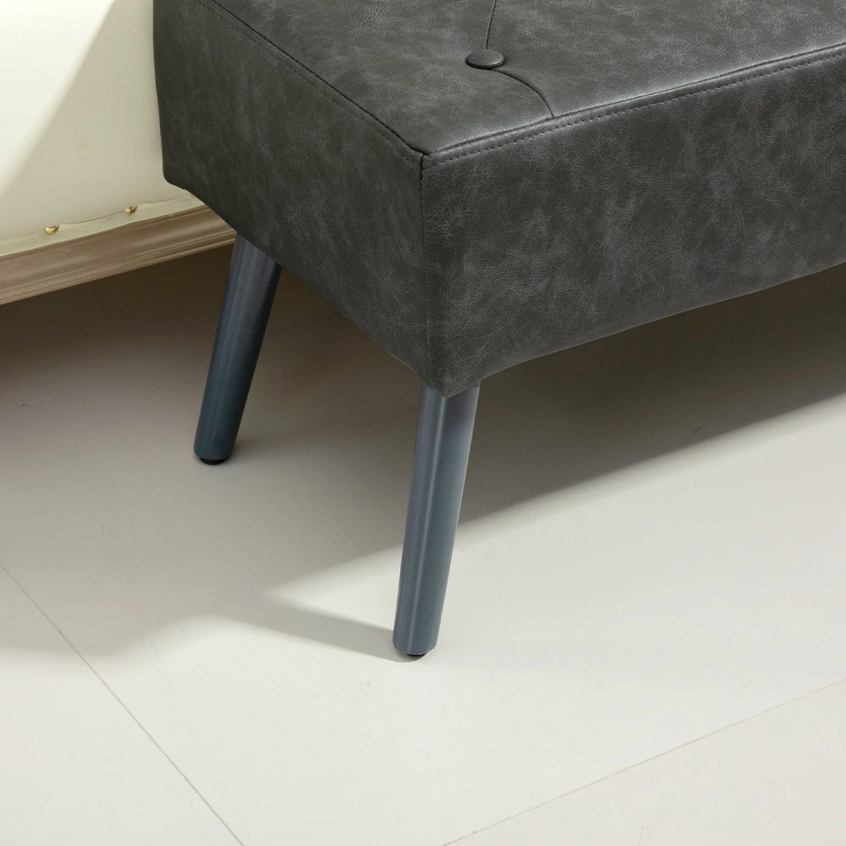 Banquette grise capitonnée sans accoudoirs, détail du pied