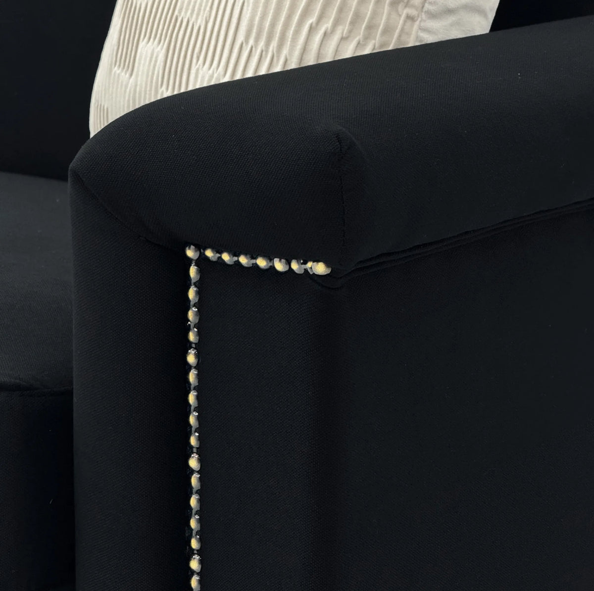 Canapé 2 places noir de 172 cm, détail de l’accoudoir et des clous décoratifs
