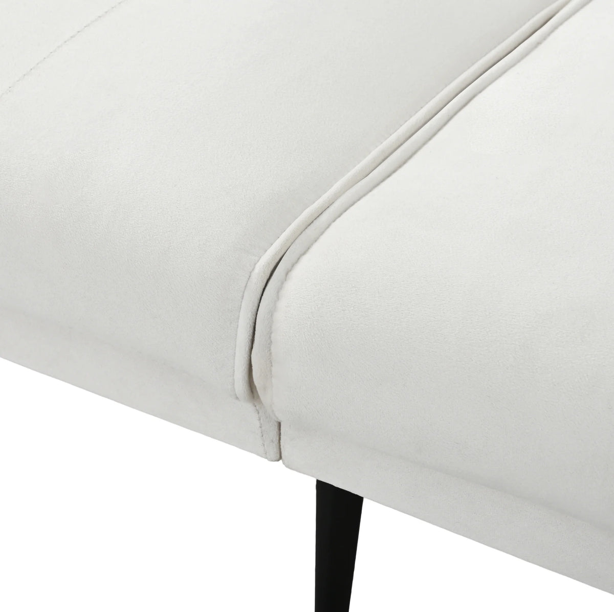 Canapé convertible beige capitonné, détail de l’assise et du pied