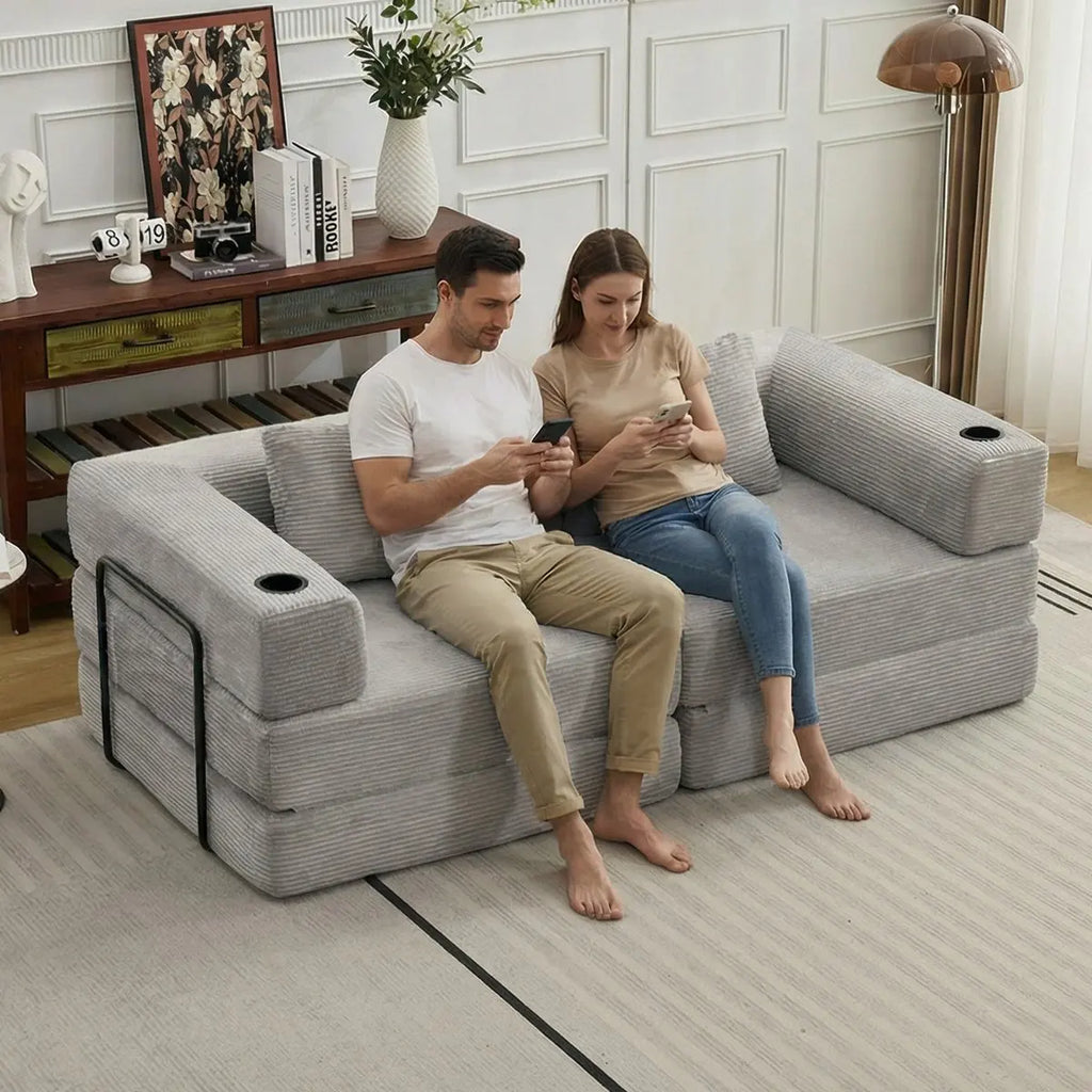 Canapé convertible gris en velours côtelé avec porte-gobelets, position assise dans un salon