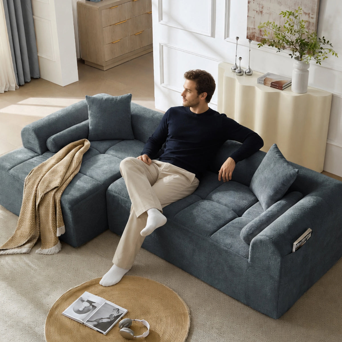 Canapé d’angle en chenille bleu gris, assise utilisée dans un salon