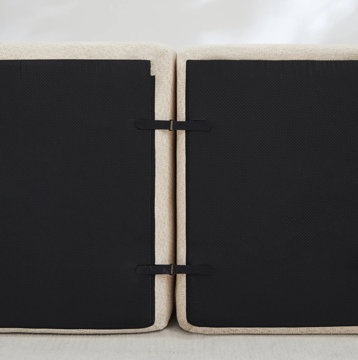 Canapé modulable à assises arrondies et deux poufs, dessous des modules et attaches