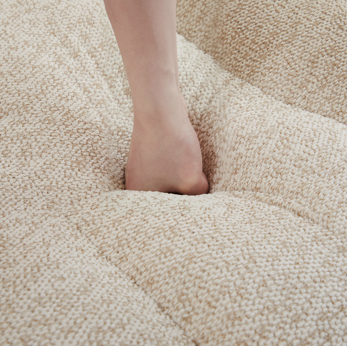 Canapé modulable à assises arrondies et deux poufs, détail du rembourrage de l’assise