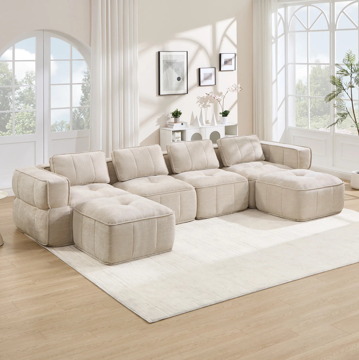 Canapé modulable beige avec deux poufs, ensemble dans un salon lumineux