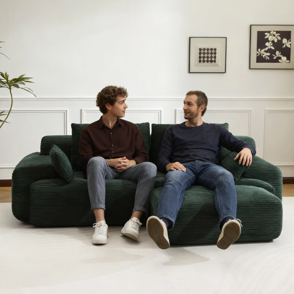 Canapé modulable et pouf en velours côtelé vert, assise utilisée par deux personnes dans un salon