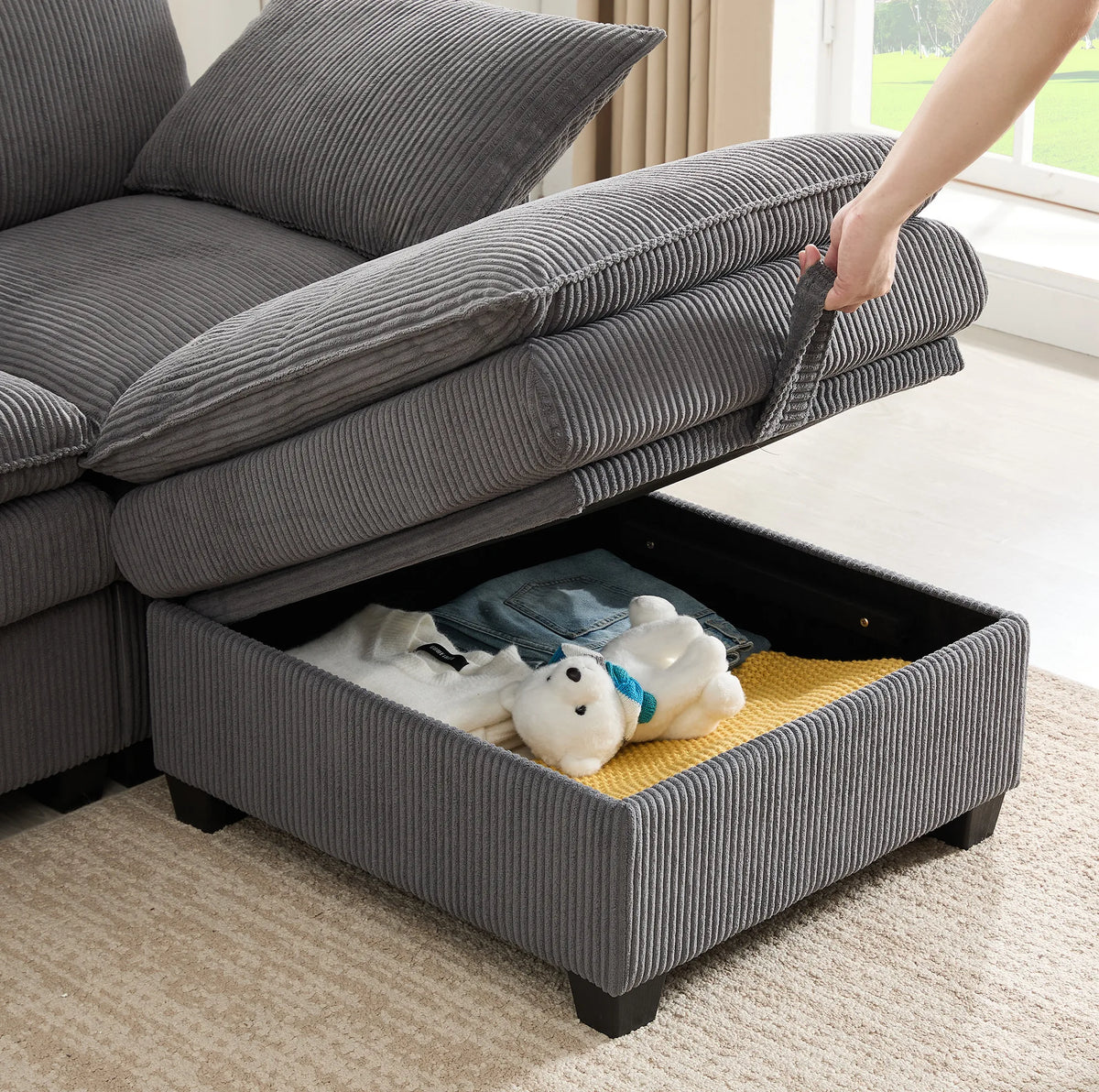 Canapé modulable gris avec rangement, détail de l’ouverture du rangement