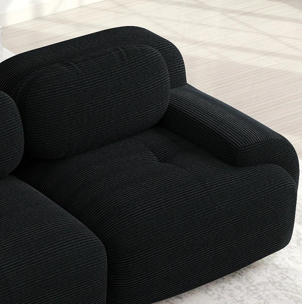 Canapé panoramique modulable en velours côtelé noir, détail de l’assise et de l’accoudoir