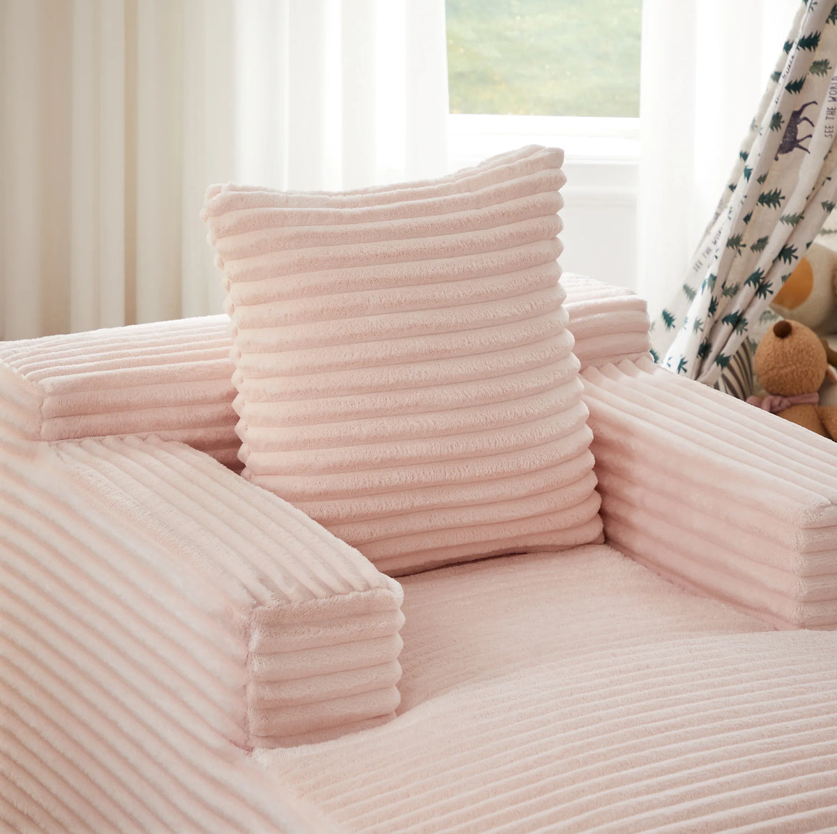 Chaise longue rose en velours côtelé, détail de l’accoudoir et du coussin