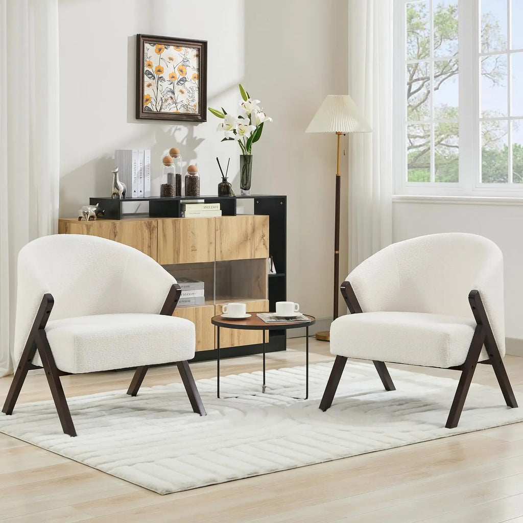 Fauteuil blanc en tissu bouclé à structure en bois foncé, deux exemplaires présentés dans un salon