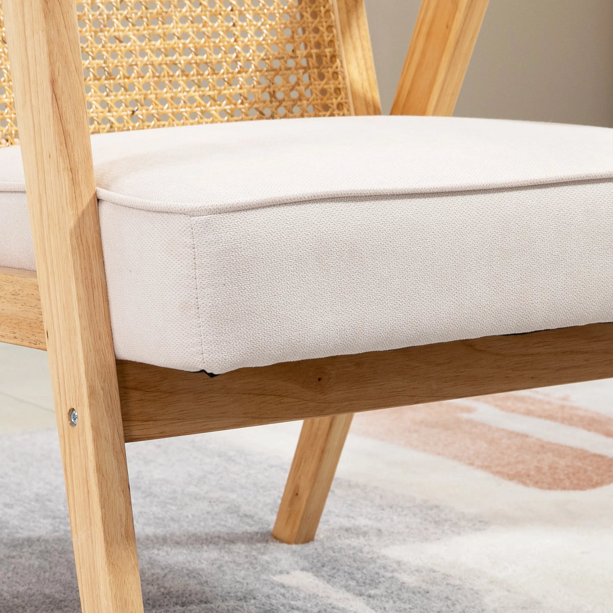 Fauteuil d'appoint en rotin et bois, détail du coussin d'assise beige