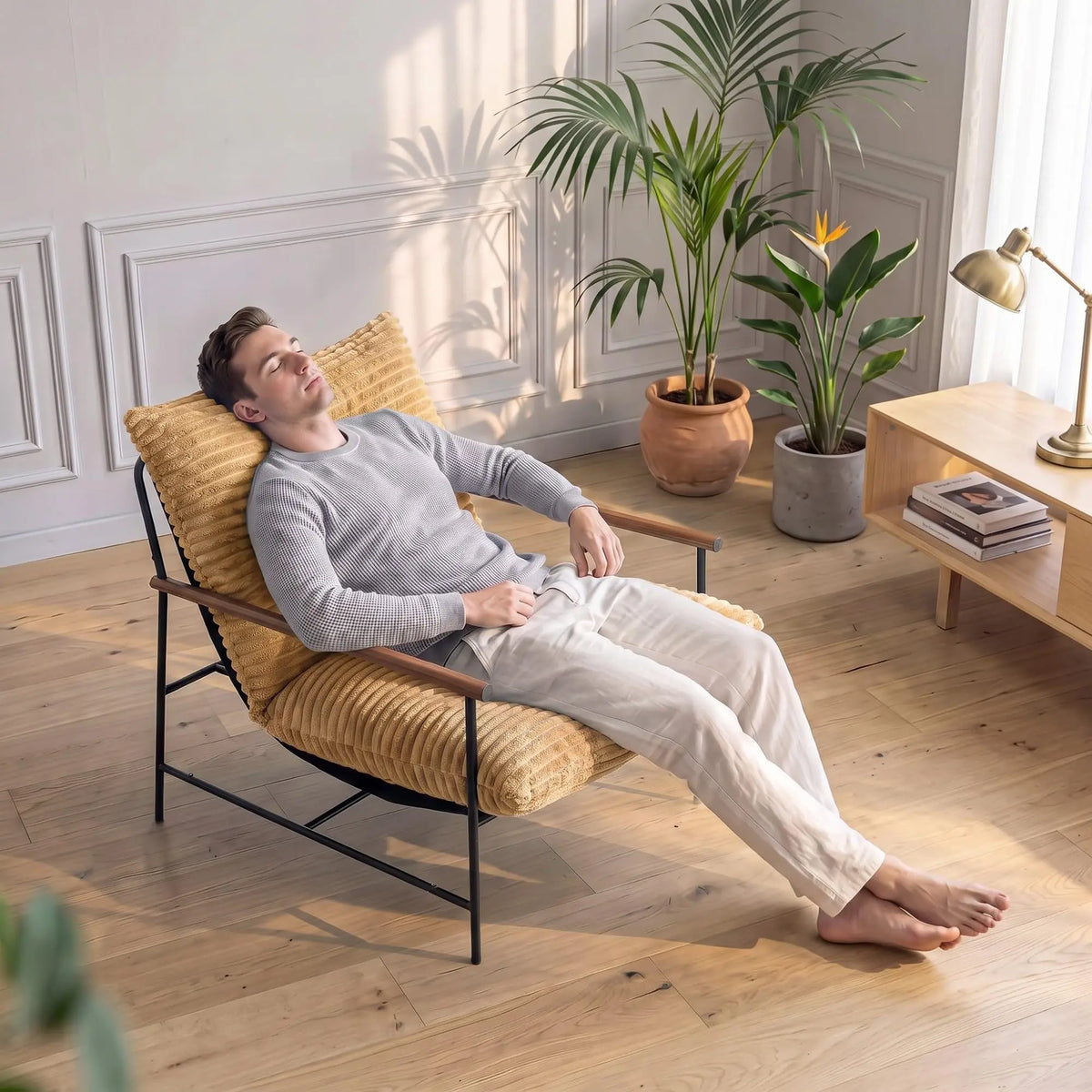 Fauteuil de détente côtelé brun clair à cadre métal et accoudoirs bois, assise utilisée dans un salon