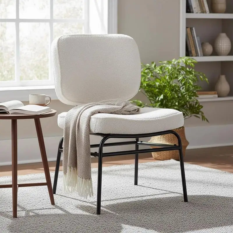 Fauteuil en sherpa crème à structure métal noire, dans un salon lumineux