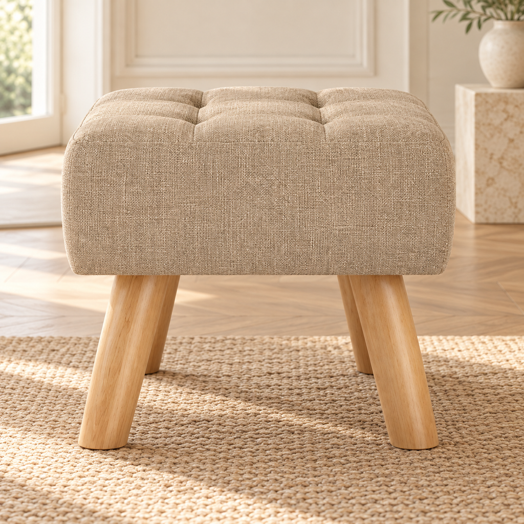 Repose-pieds beige capitonné à pieds en bois, autre angle dans un salon lumineux