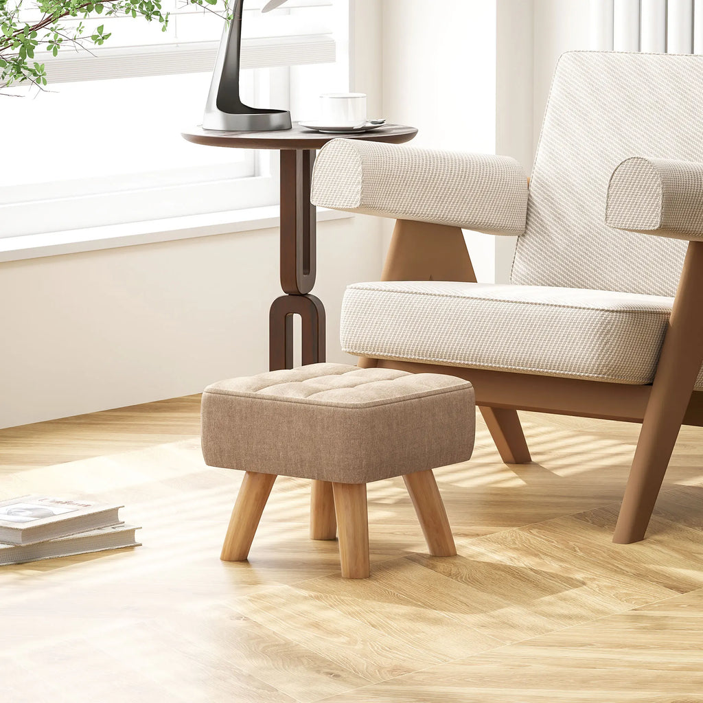 Repose-pieds beige capitonné à pieds en bois, dans un intérieur
