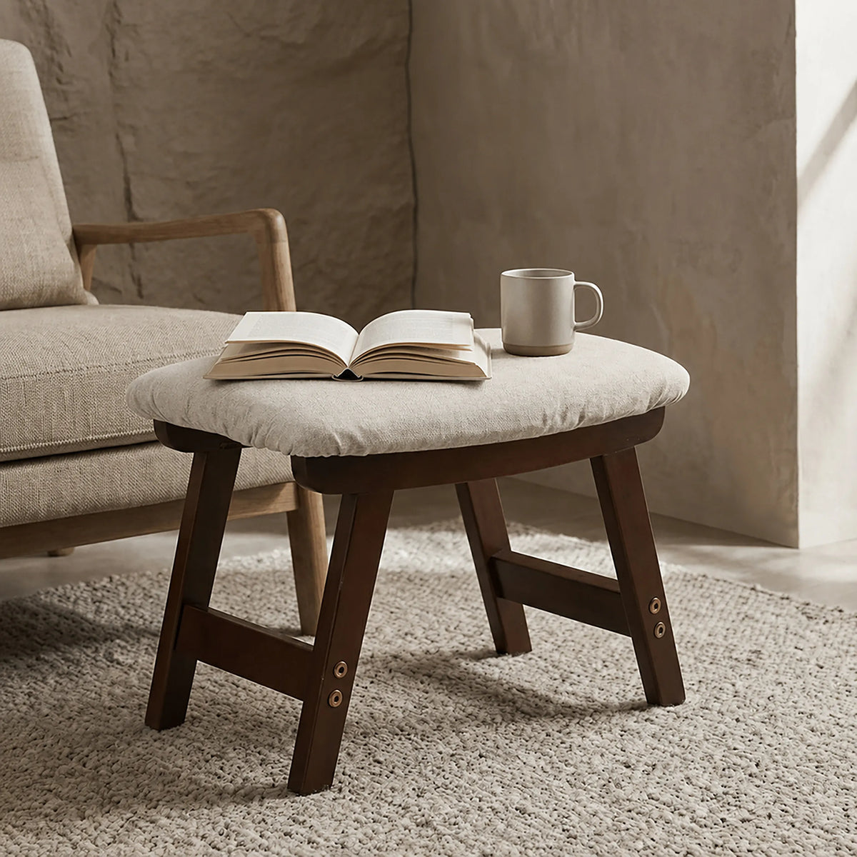 Repose-pieds en bois avec coussin, présenté avec un livre