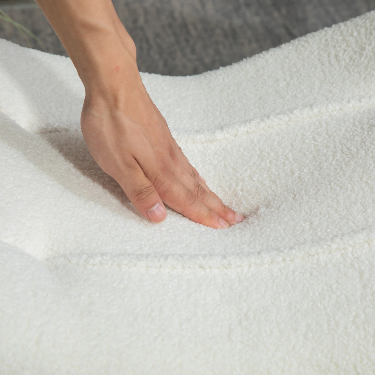 Repose-pieds incurvé en polaire crème à pieds bois, détail du tissu polaire et du rembourrage